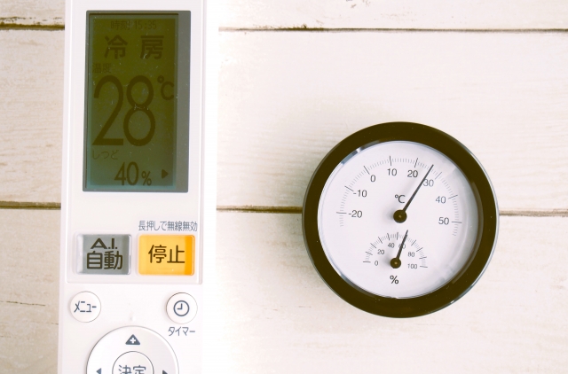 冷房のリモコンと温度計 快適な室内のイメージ