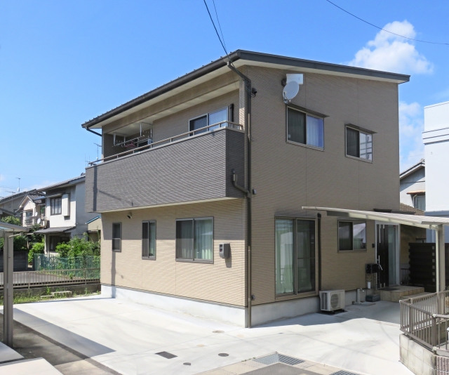 広い駐車場付きの二階建て住宅