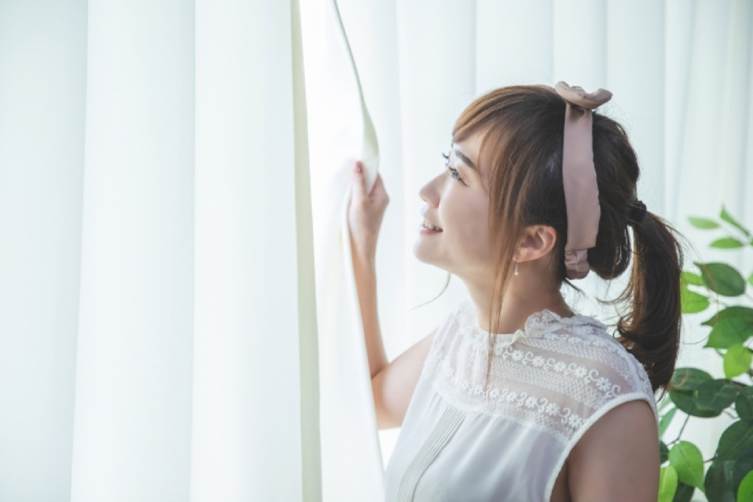 カーテン開ける女性