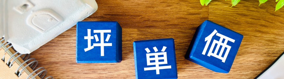 坪単価の文字が書かれた青いキューブが机の上に並んでいる様子