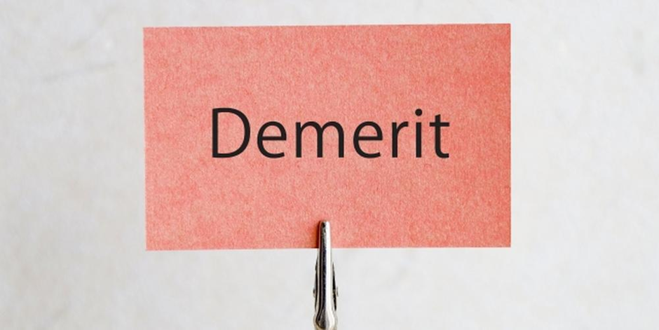 赤いカードに「Demerit」と書かれ、同様にクリップで立てられた構図