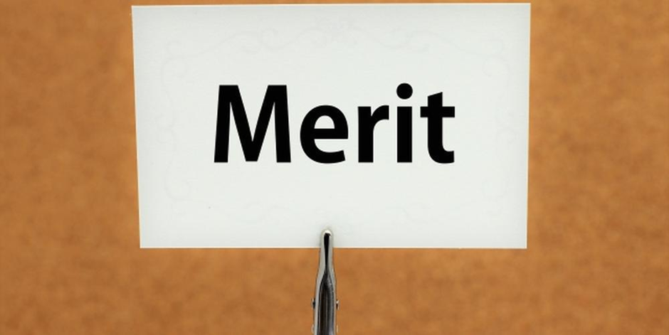 クリップで立てられた白いカードに「Merit」と書かれたイメージ