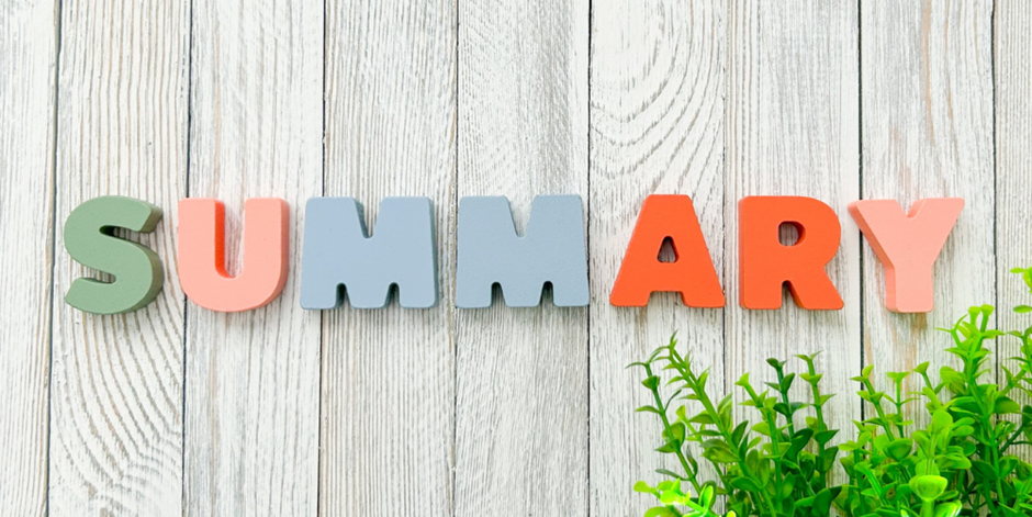木目背景に並べられたカラフルな「SUMMARY」の文字と観葉植物