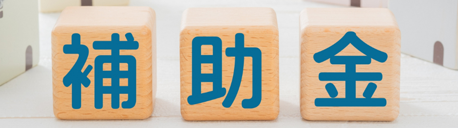 補助金という文字が描かれた木製ブロックのアップ