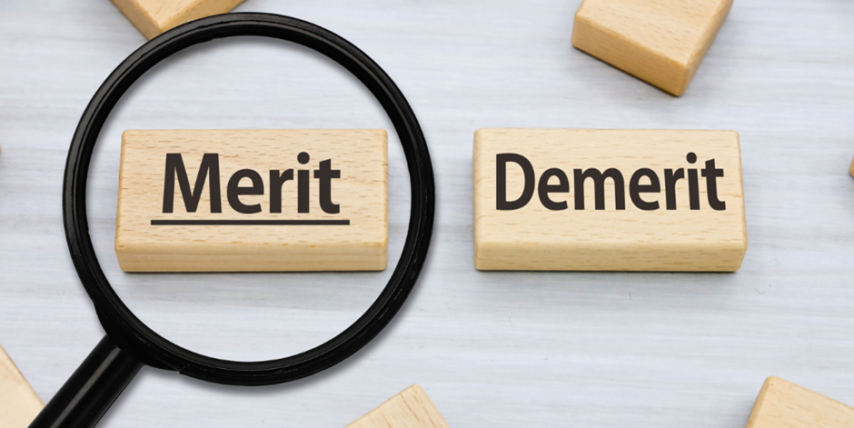 「Merit」が拡大表示された木製ブロックと虫眼鏡