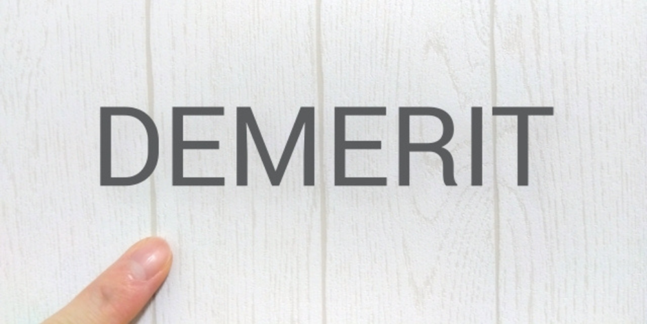 木目の背景に「DEMERIT」の文字と指差し