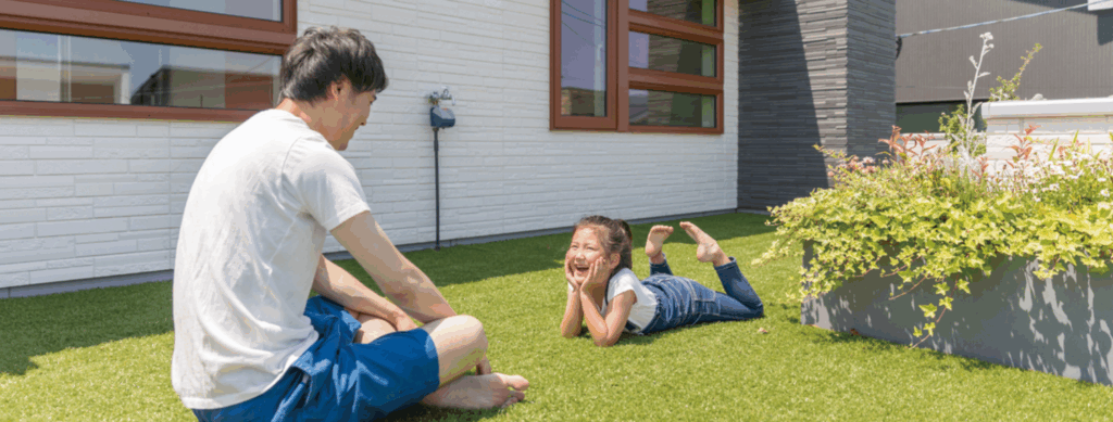 住宅の庭で寝転ぶ家族