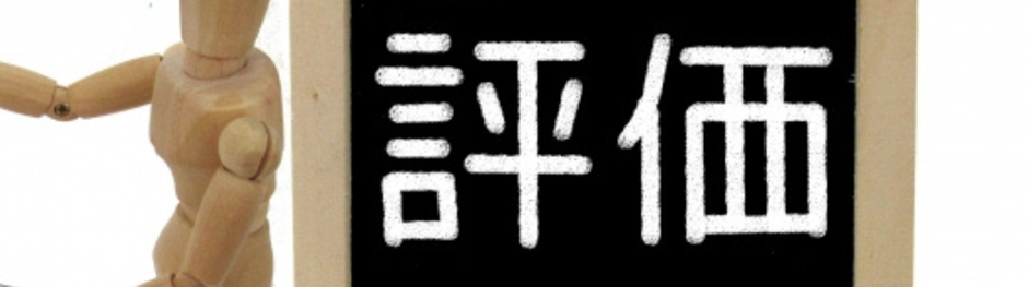 木製人形が「評価」と書かれた黒板を持つシンプルな構図のイメージ