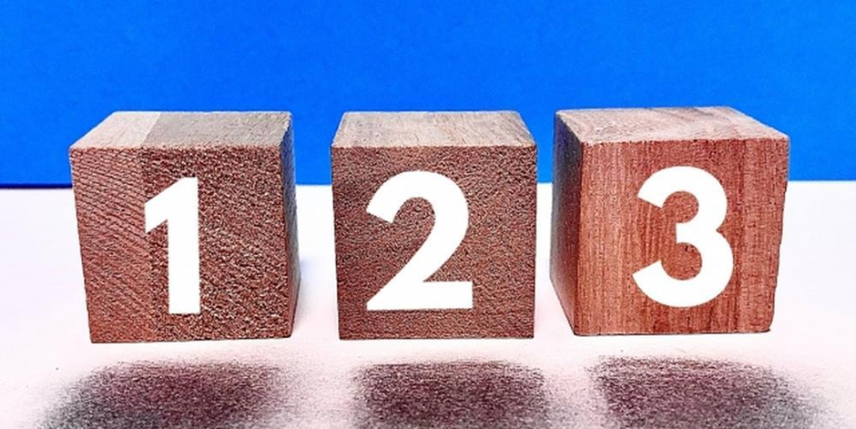 青い背景の前に並べられた木製ブロックに「1」「2」「3」の数字が描かれたイメージ画像