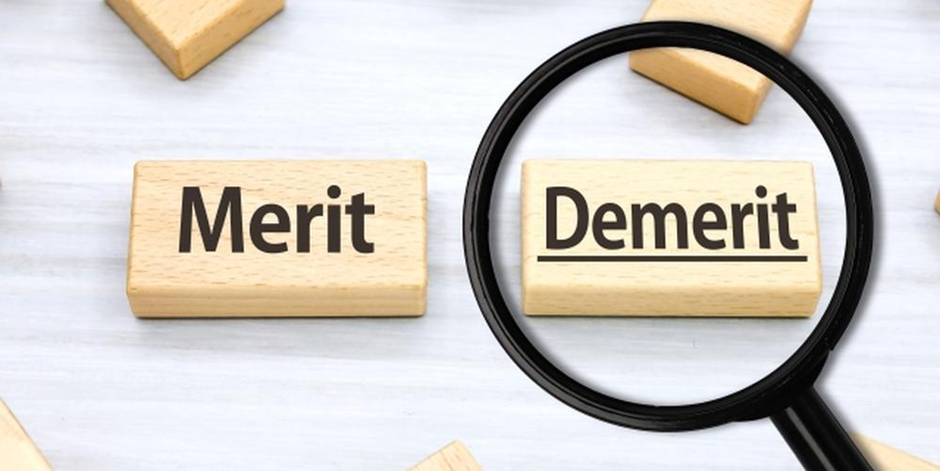 「Demerit」の文字が拡大鏡で強調された木製ブロックの画像