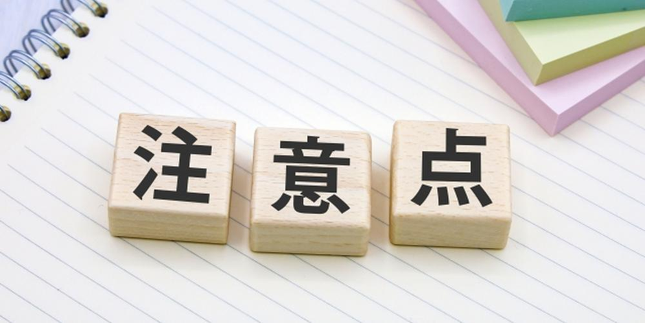 ノートの上に置かれた「注意点」の文字ブロックとカラフルな付箋が映った画像