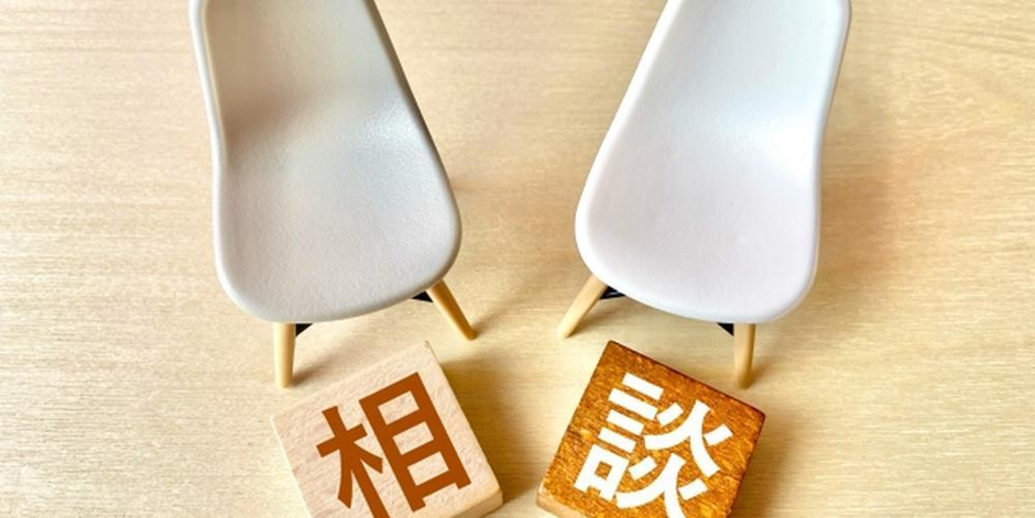 二脚の椅子と「相談」の文字ブロックが並んだ対話・打ち合わせをイメージさせる画像