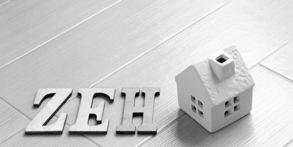 「ZEH」の文字と家の模型が並んだゼロエネルギー住宅を示す白黒のイメージ画像