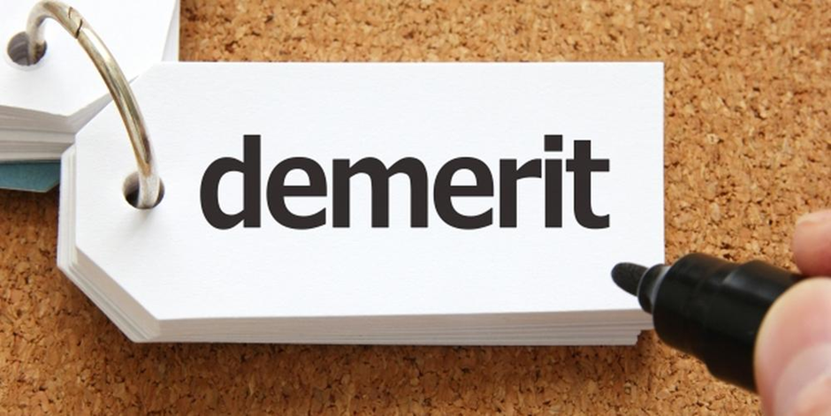 「demerit」と書かれたタグ型カードに黒ペンを添えた画像