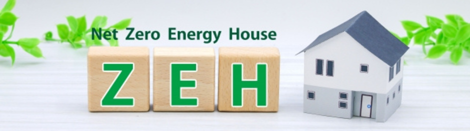 木製ブロックに「ZEH」の文字と家の模型、背景に緑の葉、Net Zero Energy Houseの説明付き