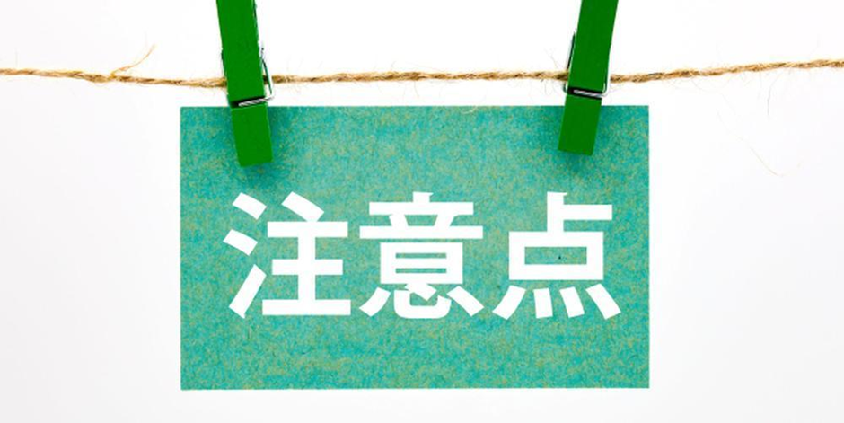 緑の紙に白文字で「注意点」と書かれた札が洗濯ばさみで吊るされているイメージ