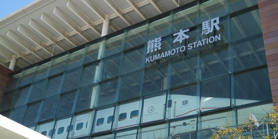 熊本駅のガラスファサードに映える「熊本駅」の駅名と停車中の新幹線の車両