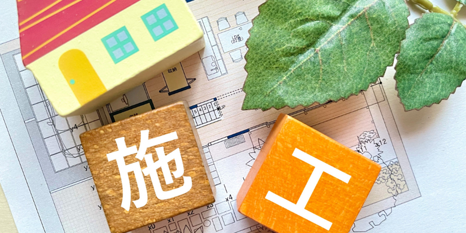 住宅の設計図と積み木の家、施工を表す木製ブロック