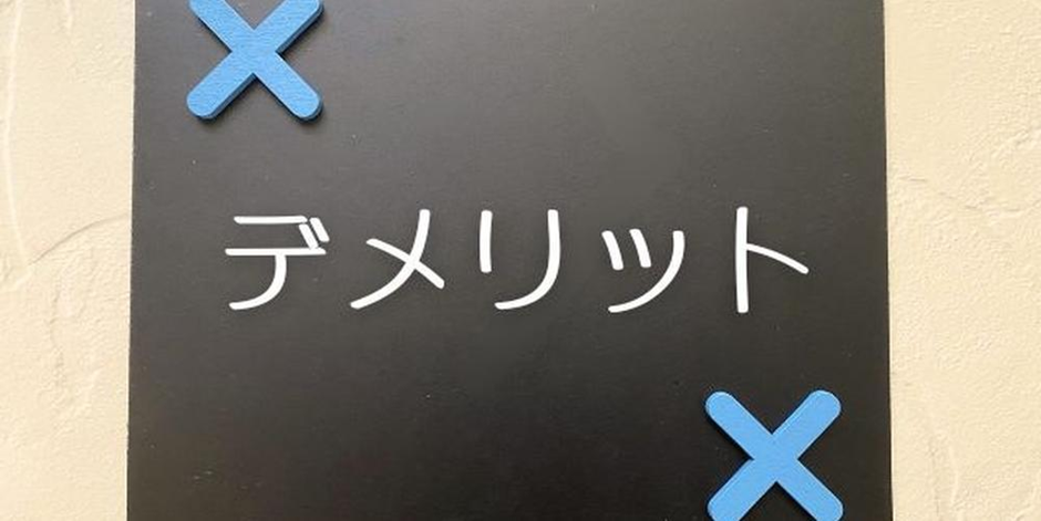 黒い背景に白文字で「デメリット」と書かれた画像、青いバツ印がアクセント